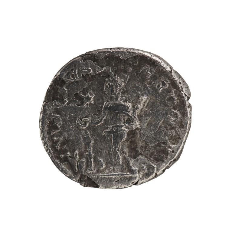 Denarius, Elagabalus 204–222; Roman emperor 218–222. Obv.: IMP ANTONINVS PIVS AVG — Bust of Elagabalus with a laurel wreath and paludamentum facing right; pearl border. Rev.: INVICTVS SACERDOS AVG — Elagabalus wearing a laurel wreath and long robe, standing left, holding a patera above an altar in his right hand and a scroll in his left hand; star at the top in the left field; pearl border. Rome, 218–222. Roman Empire. Coin; diameter ~27.5–28.5 mm; weight 2.97 g., A worn round metal object with an uneven edge sits against a white background; the surface shows textured irregularities and shallow relief suggesting faint shapes and contours, with visible areas of dark gray and lighter silvery gray tones across its face, and small patches of slightly darker shadowed gray near the rim.