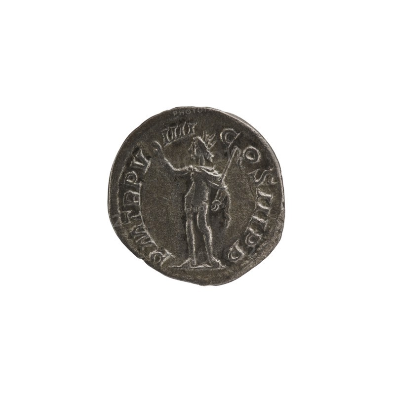 Denarius: Roman deities, Sol; Alexander Severus Roman emperor, 222–235 — iconography; dated 230; Roman Empire 27 BC–476, Rome mint; coin; diameter 18.0–19.0 mm; weight 2.11 g, A round metallic coin with a dark gray surface and lighter silver highlights showing wear, featuring a raised central figure of a standing person holding a long staff in one hand and gesturing with the other; the figure appears detailed with a headdress or rays around the head and drapery or garment outlines on the body. The coin edge has an irregular, slightly worn rim and raised decorative border elements. The background is plain white, and the visible colors are dark gray and silver.