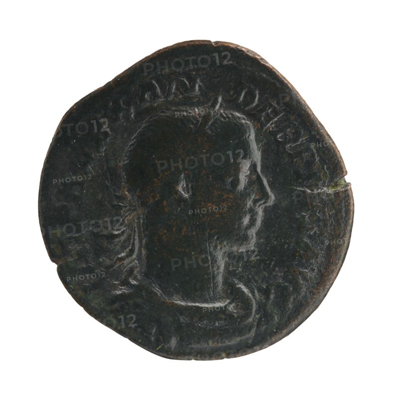 Sestertius of Severus Alexander reigned 222–235 CE, Roman imperial coin depicting Jupiter; obverse/issuer: Severus Alexander Roman emperor, 222–235 — iconography dated circa 231–235 CE, struck in Rome. Roman Empire 27 BCE–476 CE. Coin; diameter ~30–31 mm; weight 16.93 g., A round, dark coin with a worn profile of a head in relief facing right, showing the forehead, nose, lips, chin, and neck; the coin surface is mottled with patches of brownish rust and darker green-black patina, and there are a few lighter highlights where the relief is smoother; the coin edge is irregular and slightly chipped in places.