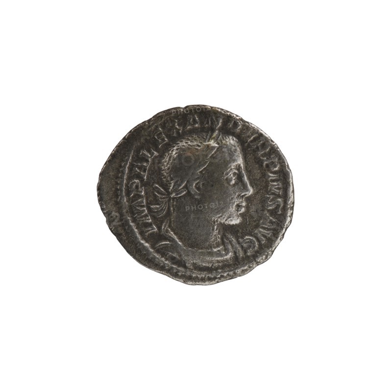 Denarius of Alexander Severus reigned 222–235. Obverse: portrait of Alexander Severus Roman emperor, 222–235. Reverse: Mars Roman deity. Iconography dated 231–235. Roman Empire; Rome mint. Coin; diameter 17.5–20.0 mm; weight 2.66 g., A round metallic object with a worn, textured surface showing a raised profile of a person facing right, with short hair and a laurel-like element at the back of the head; the object is primarily dark gray with areas of lighter gray highlights and subtle brownish tones, and it sits against a plain white background.