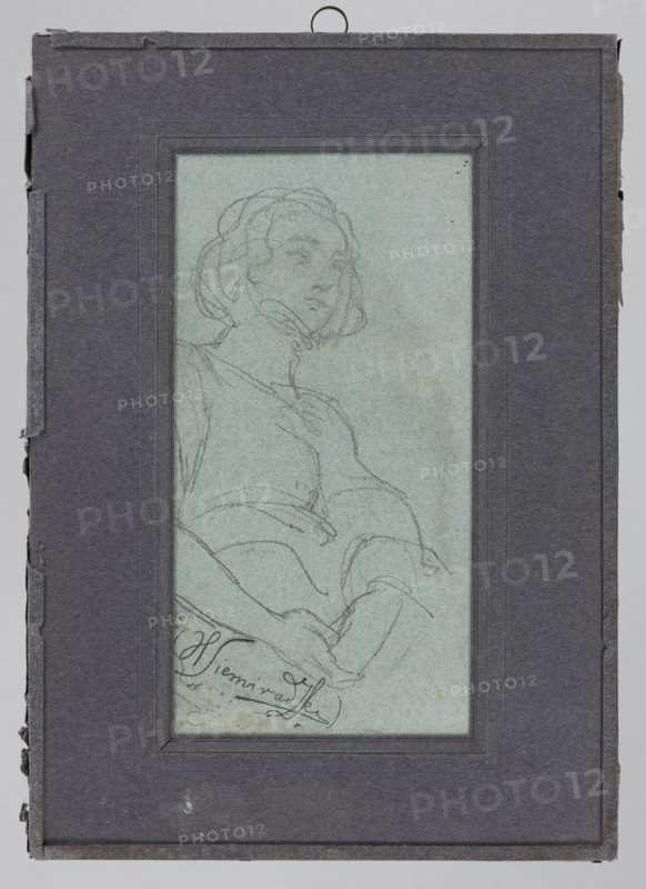Sketch of a female figure by Henryk Siemiradzki 1843–1902. Pencil drawing, before 1902. Subject: female figure/female portrait. Dimensions: height 18.2 cm, width 9.3 cm. Polish drawing., A framed pencil sketch of a seated person shown from the waist up, drawn on pale blue paper and mounted within a dark gray mat; the figure has short wavy hair and a calm facial expression, wearing a loose top with visible folds and hands resting in the lap, and there are several delicate pencil lines and light smudges around the figure.