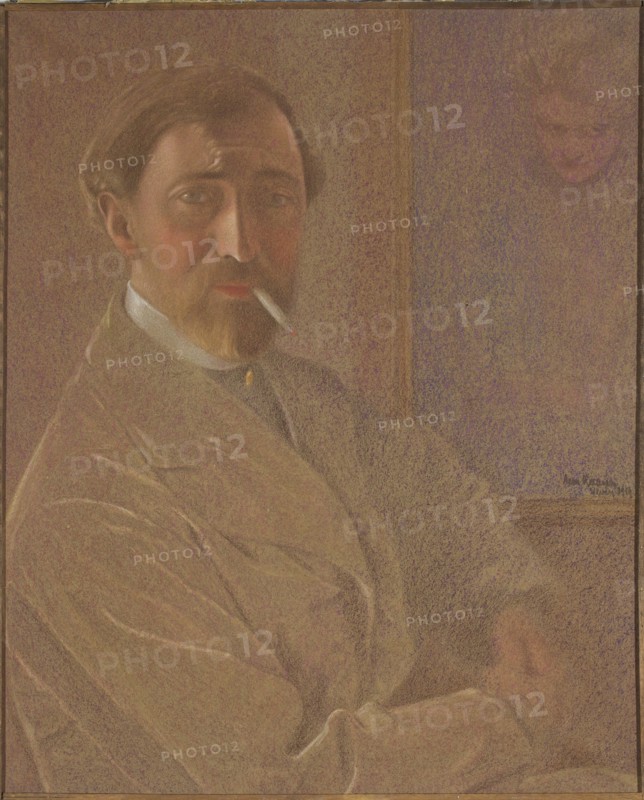 Self-portrait with a cigarette; Leon Kaufmann Kamir, 1872–1933; pastel drawing; 1919; self-portrait of a male painter smoking a cigarette; height 61.5 cm, width 51 cm; Polish pastels; Vevey., A seated man with a light brown beard and mustache looks toward the viewer while holding a cigarette in his mouth; he has brown hair and visible facial shading in tones of peach and reddish-brown, and he wears a light-colored coat with soft folds and a dark collar beneath it. The background shows a muted wall in shades of brown and purple with a faint image of another face in the upper right, and the overall palette includes browns, beiges, purples, and touches of white and red.