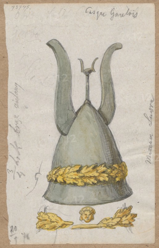 Galician helmet; verso: sketch of a male figure; draughtsman Aleksander Lesser 1814–1884;, noted; army, militaria, armor, helmets; knightly armor; draughtsman Emilian Lesser 1848–1912 also noted; draughtsman Wiktor Stanislaw Zygmunt Lesser baron; 1853–1935 also noted; sketches on both sides of a sheet of paper, glued to cardboard in two places with its side edge in brown tone; 1878, Paris; drawing; drawing: height 13.0 cm, width 8.2 cm; cardboard: height 34.8 cm, width 24.7 cm., A hand-drawn and colored depiction of a tall helmet with two upward curving horns and a central vertical ornament, rendered mostly in muted gray-green tones; a wide decorative band around the lower part of the helmet is colored bright yellow with darker yellow and brown shading to suggest texture; below the helmet are several small decorative motifs also in yellow and brown, including a small rounded element and two leafy or feather-like clusters flanking a short horizontal piece; the background is a light off-...