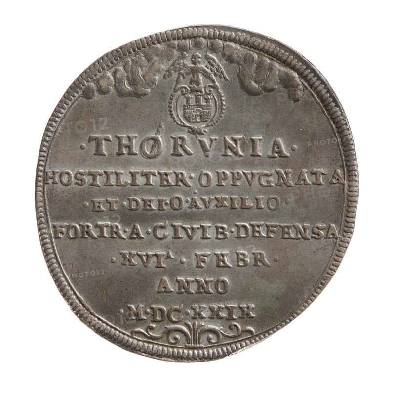 Torun siege medal thaler, Sigismund III Vasa (King of Poland; 1587–1632), medal thaler, Torun (Kuyavian-Pomeranian Voivodeship). Obv.: Coat of arms of Torun, below an inscription in seven lines: .THORVNIA. HOSTILITER.OPPVGNATA .ET.DEI.O AVXILIO. FORTR.A.CIVIB.DEFENSA. .XVIA . FEBR. Reverse: View of burning Torun with the Vistula River in the foreground. Below the river line, a small, partially erased date is visible: 1, 0. Two angels with a wreath hover over the city. In the rim, an inscription divided at the top by an ornament: FIDES . ET . CONSTANTIA . PER . IGNEM . PROBATA .ANNO. MDC.XXIX. Below an ornament. 1629. Poland, Torun, coin, dia. 47.6 mm