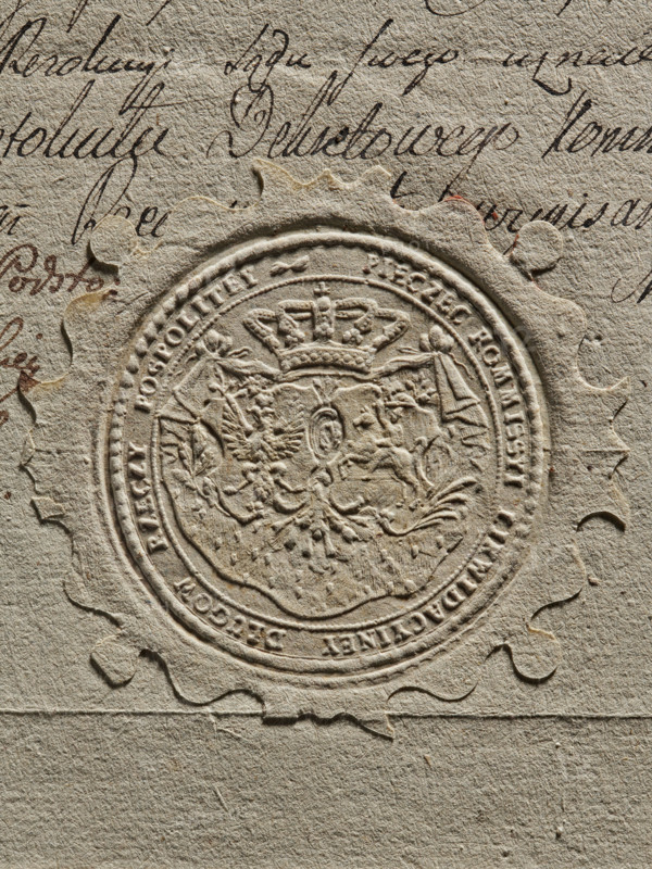 Round imprint of the seal of the Debt Liquidation Commission of the Republic of Poland. On the ermine cloak, under the crown, are two coats of arms cartouches with the Crowned Eagle and the Chaser. Around the rim, the inscription: PIECZEC KOMMISSYI LIKWIDACYINEY DLUGOW RZECZY POSPOLITEY. The document concerns filing a complaint to the court against the Crown Treasury for non-payment of wages. 1775, Poland. seal, A close-up of textured beige paper showing an embossed circular seal with a scalloped outer edge and intricate raised design in the center including a crown and ornamental shapes, surrounded by a raised border; the paper has a few areas of darker beige and brownish stains and a group of flowing dark brown handwritten strokes visible near the top and left edges.