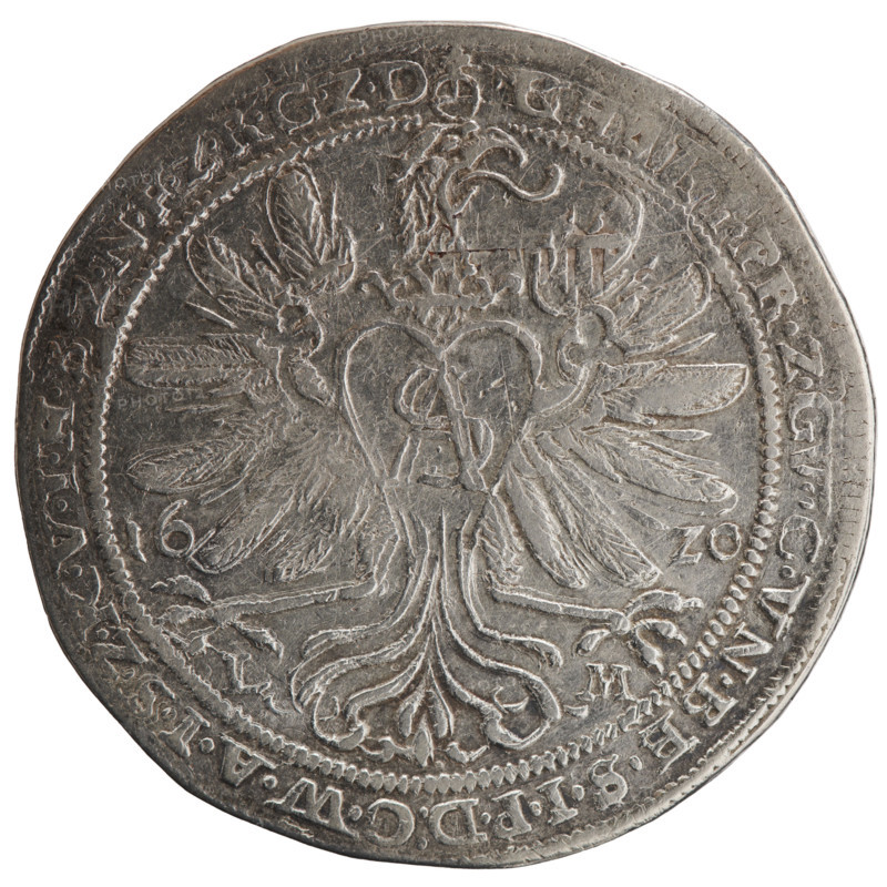 Thaler; obverse: torso facing right in a ruff and decorative armor girded with a sash, a scepter in his right hand, left hand resting on a helmet with raised visor and plume standing on a table; figure's head divides the inner border; rim between borders with inscription beginning with an orb royal GE, .WIL, LVGGMARC.Z.BRAN.DE.HEI.RO.REI.ERT.CA.VN. Reverse: Prussian eagle, on its breast within a crowned heart shield a monogram composed of the letters SA; date numerals 16 - 20 flanking the eagle; rim between borders with inscription starting with an orb, PR.ZG, C.VN.BE.SIPD:CWAISZKVIHBZNFZRGZD; under the eagle's claws, on both sides L - M, 1620. Portrait/subject: George William of Hohenzollern (Elector of Brandenburg; Prince of Prussia; 1620–1640) — Ducal Prussia (1525–1701). Coin: diameter 44.2 mm, weight 28.07 g, axis 225°.