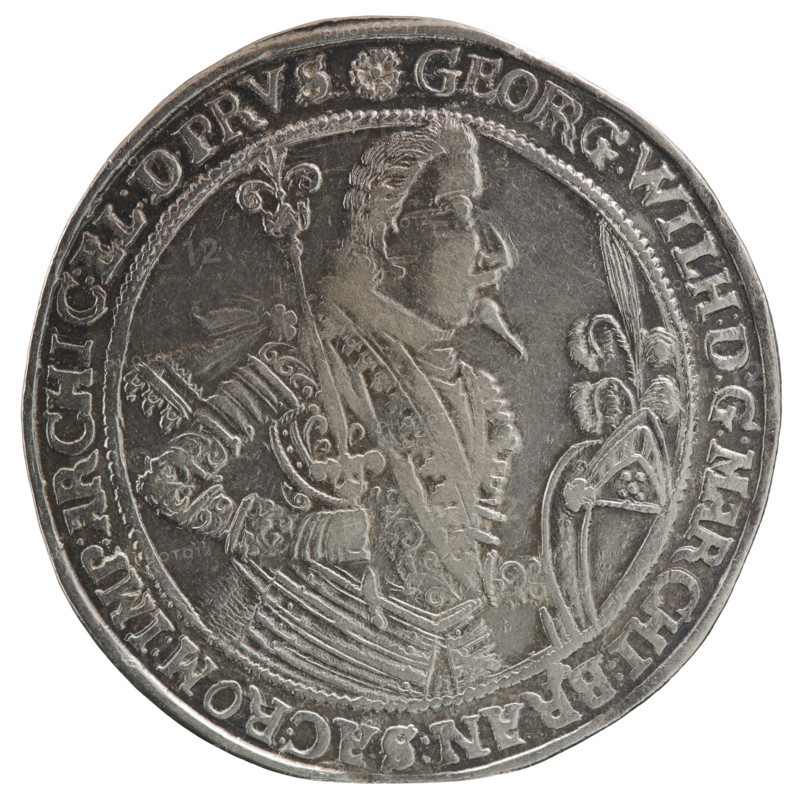 Thaler depicting male bust in armor: George William of Hohenzollern (Elector of Brandenburg; Duke of Prussia; 1620–1640) — Obverse: torso facing right in collar and decorative armor, girded with a sash, sceptre in right hand, helmet with raised visor and plume in left hand; rim inscription beginning with a rosette GEORG:WILH:D:G:MARCHI:BRAN:SAC:ROM:IMP:ARCHIC:EL:D.PRVS. Reverse: twenty-four-field coat of arms with ornaments topped with seven jewels; date digits 16 -34 separated by jewels; half-rim inscription ending with a heart +ANFANCK.BEDE, CK.DAS.ENDE, 1634. Ducal Prussia (1525–1701), Königsberg. Coin: diameter 44.7 mm, weight 28.26 g, axis 60°.