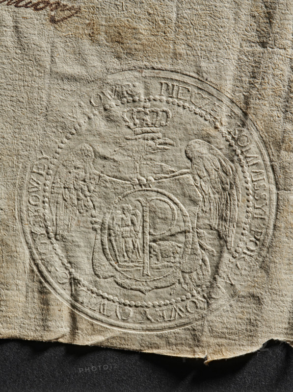 Round dry impression of the seal of the Civil-Military Order Commission of Owruck County, 1790. Round impression showing in the field a crowned eagle with its head facing left; on the eagle a decorative shield bearing St. Michael holding a downward-pointing sword in one hand and a sword scabbard in the other, with a central capital letter P and a bear (coats of arms of the Kilów Voivodeship). In the rim an inscription: 'PIECZEC KOMMISSYI PORZADKOWEY CIWILNO-WOYSKOWEY POW : OWR.' Poland, Owrucki poviat., A textured, crumpled sheet with an embossed circular seal occupies most of the image; the seal shows a symmetrical design with a crowned emblem at the top, two stylized wings or bird-like forms flanking a central shield with intricate raised details, and a beaded border around the circle. The paper is mainly beige and off-white with areas of darker tan and light brown staining and slight discoloration, and there are subtle shadows emphasizing the creases and embossing. The bottom edge o...