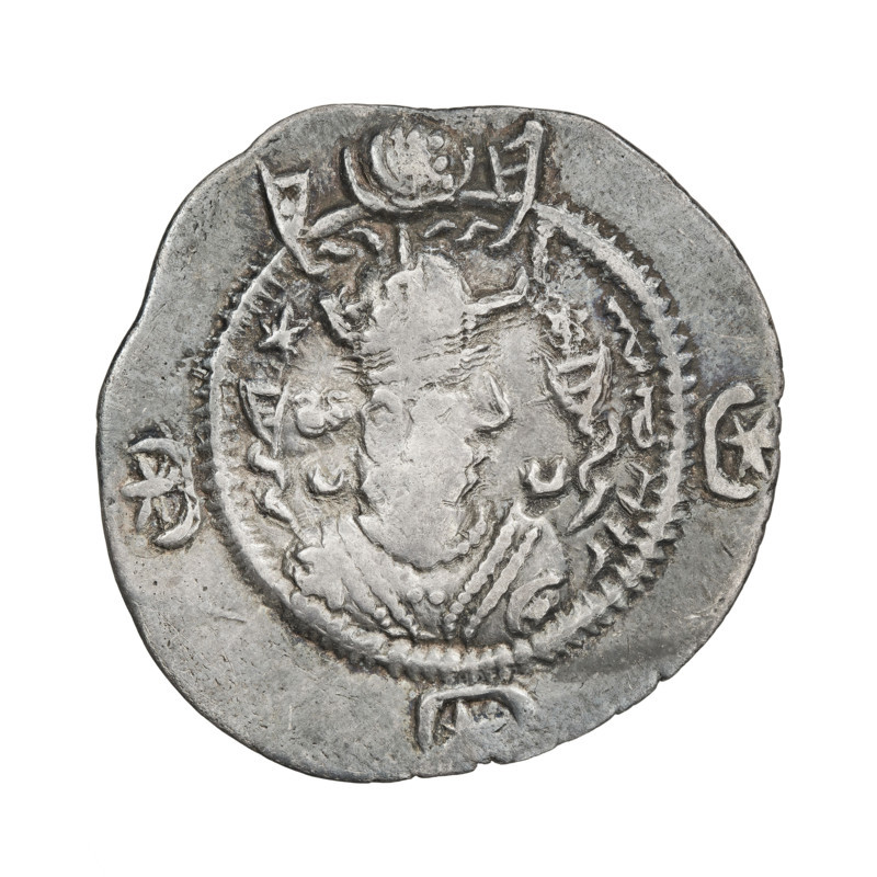 Drachma of Kavadh I (ruler of Persia; 488–496 and 498–531). Obverse: bust of Kavadh I facing right; wearing a crown with ribbons, decorated with a crescent topped by a korymbos, stars on either side, short curly beard, curly hair tied back, earring, beads and a long chain around his neck, ribbons flowing from behind his shoulders, crescents on both sides of the bust; outside the rim three crescents with a star in the center. Pahlavi legend. Reverse: fire altar; to its left the ruler stands facing forward with a sword, to its right a priest stands facing forward holding a sword; star at top left, crescent at top right, signs/monograms on both sides; pearl rim. Sassanid art, Sassanid Kingdom, Iran (Persia). Dates: 488–497, 499–531. Coin; diameter 27.0 × 28.0 mm; weight 4.04 g.