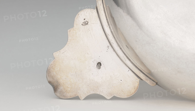 Écuelle by Louis I Dulaurier, goldsmith; tableware element. Body in the form of a smooth, circular bowl with two horizontal handles ending in shells. Cover arched, decorated with racailles and a grid, with a handle bearing a relief male bust in a laurel wreath. Engraved on both parts is a coat of arms under a count's crown (three-field: on the right, a tower on a rock on an azure field; on the left, two bulls on a gold field; above, three stars on a blue field). Dated 1690, modified 1760–1761. Toulouse. Vessel; height 13 cm, width 28.8 cm, depth 17.2 cm.