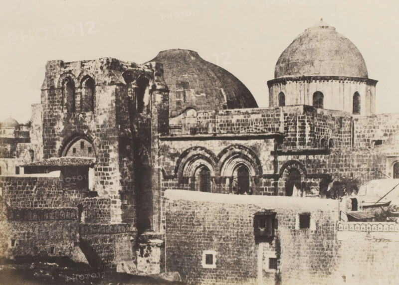 Jerusalem. Saint Sepulcre. Vue générale, View of the Church of the Holy Sepulcher in Jerusalem, photograph, page, photographer: Auguste Salzmann, Jerusalem, printer (person): Louis-Désiré Blanquart-Evrard, Lille, publisher: Gide et J. Baudry, Paris, 1854 - 1856, printer (person), pasteboard, paper, salted paper print, height 167 mm x width 233 mm, Photo on unnumbered page., church (exterior), Church of the Holy Sepulcher, A sepia-toned photograph of stone buildings with domes and arches filling the frame, showing weathered brickwork, rounded archways, rectangular windows, and a large rounded dome on the right with a smaller dome behind a central structure, layered terraces and parapets, varied masonry textures, and shadowed recesses across the façades.
