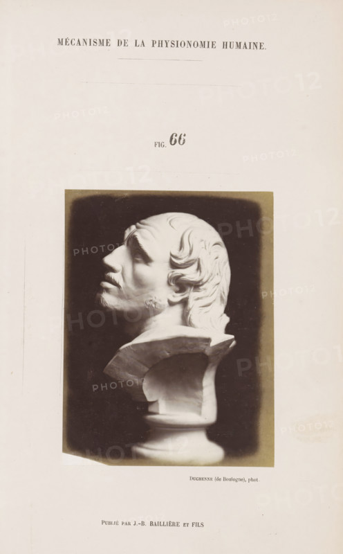 Image of 'l'Arrotino', photograph, page, Unnumbered page with photo 66 from Mécanisme de la physionomie humaine ou analyze électro-physiologique de l'expression des passions (Atlas)., photographer: Guillaume Benjamin Amand Duchenne, France, publisher: JB Baillière et Fils, Paris, c. 1860 - in or before 1862, paper, albumen print, albumendruk, height 119 mm x width 92 mm, piece of sculpture, reproduction of a piece of sculpture, experiment, test, science and technology, face, morphology of facial expression, physiology and anatomy, physiognomy, nervous system, neurology, A photographic print of a white sculpted bust shown in profile against a dark rectangular background, depicting a bearded man with wavy hair swept back, a pronounced nose, and a tilted upward gaze; the bust rests on a pedestal with a curved support and a rounded base, all positioned on a light-colored page with a header of uppercase text near the top and additional small printed text below the image.