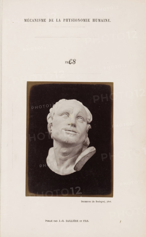 Image of 'l'Arrotino', photograph, page, Unnumbered page with photo 68 from Mécanisme de la physionomie humaine ou analyze électro-physiologique de l'expression des passions (Atlas)., photographer: Guillaume Benjamin Amand Duchenne, France, publisher: JB Baillière et Fils, Paris, c. 1860 - in or before 1862, paper, albumen print, albumendruk, height 119 mm x width 90 mm, piece of sculpture, reproduction of a piece of sculpture, experiment, test, science and technology, face, morphology of facial expression, physiology and anatomy, physiognomy, nervous system, neurology, A photographic reproduction of a sculpted head mounted on a dark rectangular background centered on a pale page; the sculpture shows a tilted face with closed or mostly closed eyes, slightly parted lips, a short beard and mustache, wavy hair swept back, and part of a neck and collar visible, the sculpture appearing smooth and light in tone against the dark surround.