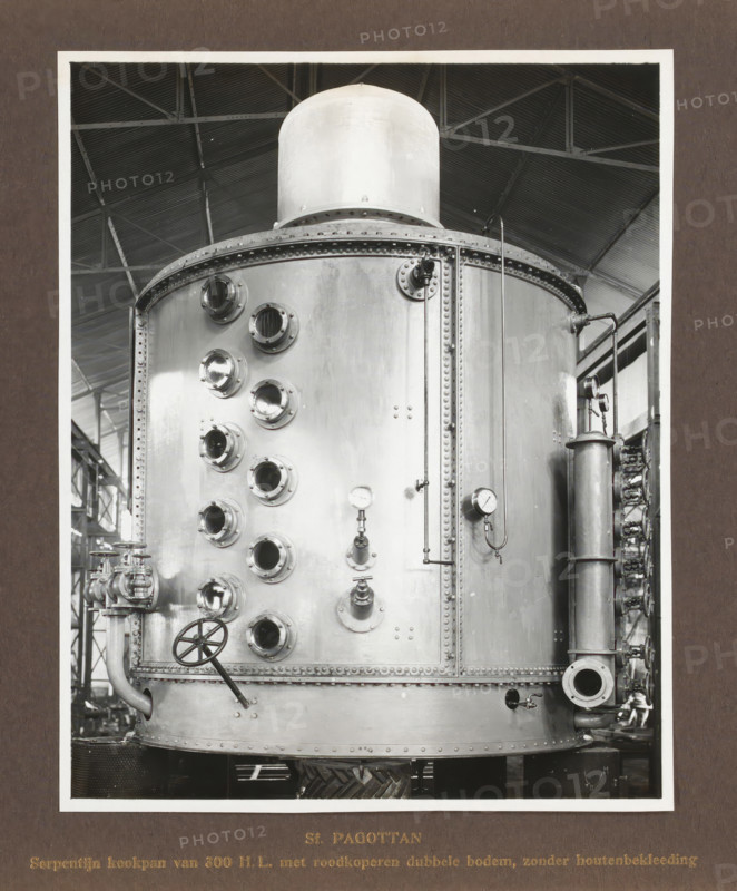 Sf. Pagottan Serpentine cooking pot of 300 HL with red copper double bottom, without wooden lining, album page, photograph, Album page with a photo of a kettle. Produced by Machinefabriek Braat and intended for the Pagottan Sugar Factory, 1922. Part of the photo album Machinefabriek Braat Soerabaia-Djocja-Tegal, ca. 1916-1924., Surabaya, 1922, photographer, Java, East Java, paper, pasteboard, gelatin silver print, height 198 mm x width 159 mm, height 240 mm x width 290 mm, Person, NV Machinefabriek Braat, Pagottan Sugar Factory, colonial system, factory-interior, machine shop, machines, parts of machines, tools and appliances, economic history, overseas history, sugar industry, company history, Period, 1916 - 1924, A large cylindrical metal tank with a domed top sits vertically, its surface showing riveted seams and round porthole-like openings arranged in a grid on the curved face; round gauges with needle indicators are mounted on the front alongside valves, pipes, and flanged connec...