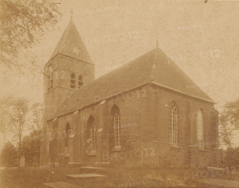 Southeast side of the Reformed Church in Westerwijtwerd, photograph, annotation: 'Westerwijtwerd, municipality of Middelstum', annotation: 'Church in Westerwijtwerd, SE view, July 1897, (municipality of Middelstum)', Westerwijtwerd, 1897, photographer, Attributed to, paper, pasteboard, albumen print, height 170 mm x width 216 mm, church (exterior), A sepia-toned photograph showing a brick church with a steep tiled roof and a square bell tower topped by a pointed spire, arched windows with multiple panes along the side wall, narrow roof dormers, and surrounding trees with foliage partially visible against a textured sky.