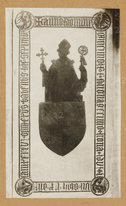 Tomb of Lamprecht von Brunn in Bamberg Cathedral, Grabplatte d. Bischofs Lambert v. Brun (1398), album page, photograph, This photo is part of an album., number: '161', Bamberg, 1900 - c. 1920, photographer, Bavaria, paper, baryta paper, gelatin silver print, height 224 mm x width 135 mm, Person, Lamprecht von Brunn, interior of church, Bamberg Cathedral, A centered metal effigy of a robed bishop wearing a mitre and holding a cross in one hand and a crozier in the other is depicted against a light rectangular panel framed by patterned borders; the bishop's robes show carved drapery lines and a decorative collar, and beneath the effigy is a large shield bearing divided heraldic designs including a diagonal band and animal motifs. The surrounding border contains circular medallions at the corners with stylized bird figures and repeated ornamental vertical bands along the sides, all set on a lighter background with a darker outer margin.