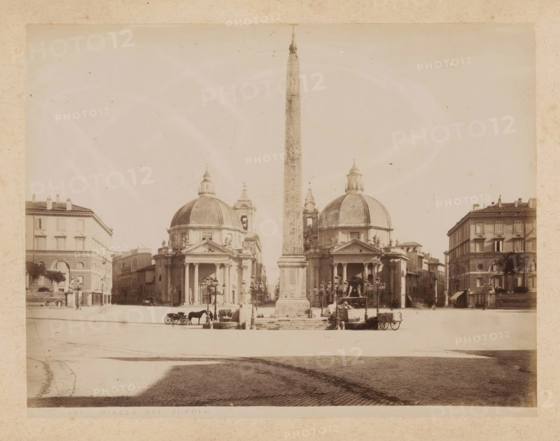 View of the Piazza del Popolo in Rome, album page, photograph, This photo is part of an album., inscription: '431 PIAZZA DEL POPOLO', Rome, 1870 - c. 1895, photographer, paper, pasteboard, albumen print, albumendruk, height 199 mm x width 258 mm, square, circus, triumphal column with helical friezes, Piazza del Popolo, A wide city square with a tall obelisk rising from a pedestal in the center flanked by two large domed churches with classical porticos and columns, ornate facades, and sculptural details; rows of buildings border the square on both sides, featuring multi-story façades with windows and tiled roofs; a cobblestone foreground leads to steps and lamp posts near the obelisk, where horse-drawn carriages, horses, and a few people are visible; the image has a faded, sepia-toned appearance and shows signs of age with light spots and subtle scratches.