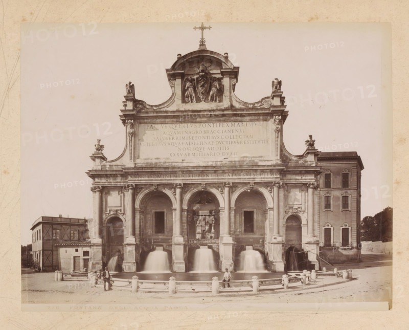 View of the Fontana dell'Acqua Paolo in Rome, album page, photograph, This photo is part of an album., inscription: '276 FONTANA DELL' ACQUA PAOLA', Rome, 1870 - c. 1895, photographer, paper, pasteboard, albumen print, height 201 mm x width 259 mm, ornamental fountain, Fontana dell'Acqua Paola, A large classical stone facade with arches and columns features sculpted figures and ornamental details along its upper cornice, including winged statues and a central sculptural group beneath a curved pediment topped by a cross; water pours from multiple arched openings into a semicircular basin in front, bordered by short stone posts connected by chains and a paved area where a few men stand and sit; flanking the main facade are adjacent multi-story buildings with windows and architectural trim, and the scene is framed by a wide expanse of pale sky above.