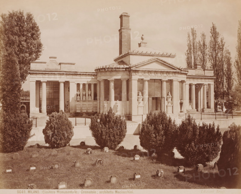 Monumenta della familglia Bruni, Cimitero Monumentale, Milan, Italy, photograph, Pyramid-shaped funerary monument of the Bruni family with marble statues in front of the entrance, cemetery, Italy., caption: '5961. MILANO. Cimitero Monumentale della familglia Bruni, architetto Colla.', photographer: attributed to Edizioni Brogi, Florence, publisher: attributed to Giacomo Brogi, c. 1865 - c. 1890, Tuscany, Attributed to, pasteboard, paper, albumen print, height 250 mm, width 197 mm x width 330 mm, height 492 mm, A wide front view of a classical stone building with a central dome and a tall rectangular chimney rising behind it, flanked by colonnaded wings and topped with decorative urns and sculpted details, set behind a low stone balustrade and a row of sculpted vases on pedestals at the entrance; the foreground shows a grassy area with numerous small grave markers and scattered stones, and a line of trimmed evergreen bushes rising in front of the building, while tall poplar trees frame ...