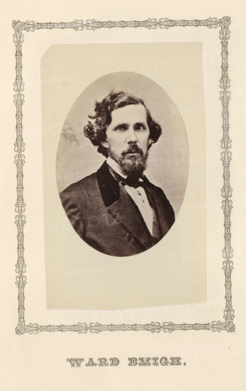 Ward Emigh, photograph, page, c. 1876 - in or before 1881, photographer, paper, albumen print, height 97 mm x width 60 mm, adult man, An oval-framed black-and-white portrait of a man with wavy hair and a full beard and mustache, wearing a dark suit jacket, a white shirt, and a bow tie, centered on a light rectangular mat with decorative patterned borders along the page edges.