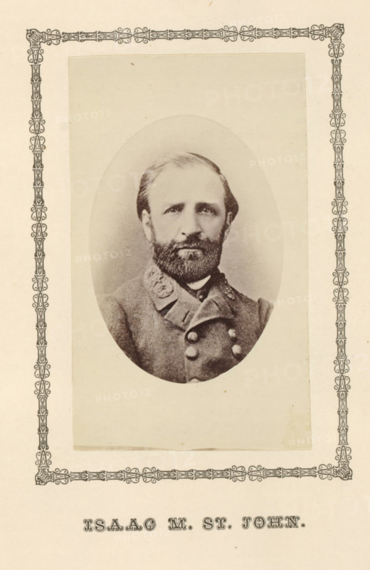 Isaac M. St. John, photograph, page, c. 1876 - in or before 1881, photographer, paper, albumen print, height 100 mm x width 60 mm, Person, Isaac Munroe St. John, officer, A faded oval photographic portrait of a bearded man wearing a double-breasted uniform jacket with decorative collar details, mounted on a rectangular sheet with an ornate decorative border around the photo area.