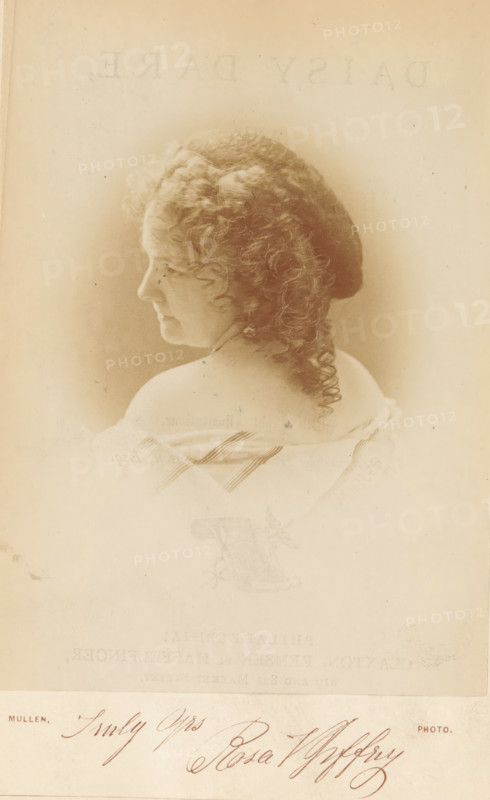 Daisy dare, and baby power, book, inscription: 'Clinton Hall for the use of the mercantile library association NY', writer (clerical worker): Rosa Vertner Jeffrey, publisher: Claxton, Remsen & Haffelinger, Philadelphia, 1871, writer (clerical worker), North America, textile materials, pasteboard, paper, linen (material), printing, albumen print, color on cut, height 209 mm x width 150 mm x thickness 12 mm, A faded sepia portrait of a woman shown from the shoulders up in profile facing left, with curly hair piled and coiled at the back, wearing an off-the-shoulder garment that reveals her bare neck and upper back, photographed against a plain light background with soft vignette shading around her head, and a handwritten signature visible near the bottom edge.