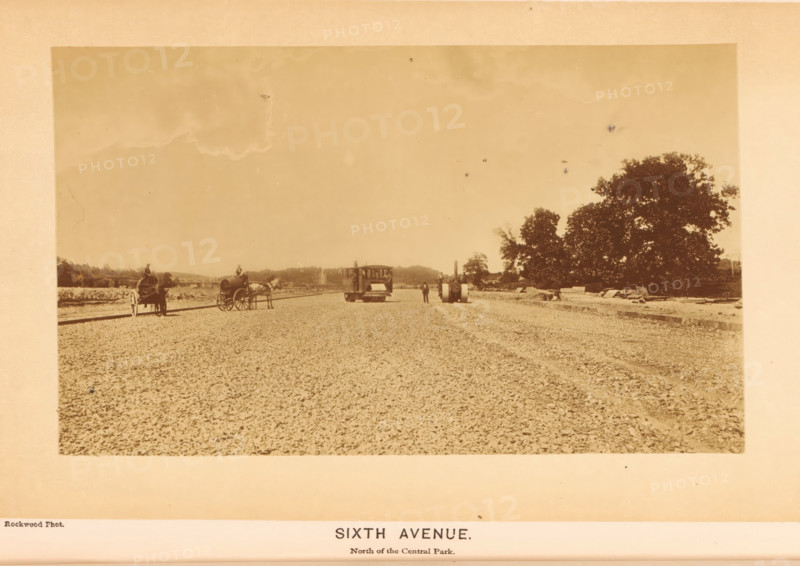 Sixth Avenue, photograph, page, photographer: George Gardner Rockwood, Central Park (New York), c. 1866 - in or before 1871, North America, New York (city), paper, albumen print, height 103 mm x width 166 mm, public gardens, park, avenue, boulevard, promenade, esplanade, A wide sepia-toned photograph shows a rough, gravel-covered roadway stretching from foreground to background with a small horse-drawn carriage and a second horse hitched to a wagon positioned along the left side, a boxy wooden vehicle about mid-distance near the center with a person standing beside it, a cylindrical steamroller or similar heavy roller slightly to the right with a person nearby, and a large leafy tree cluster on the right edge with scattered construction materials along its base under an expansive sky.