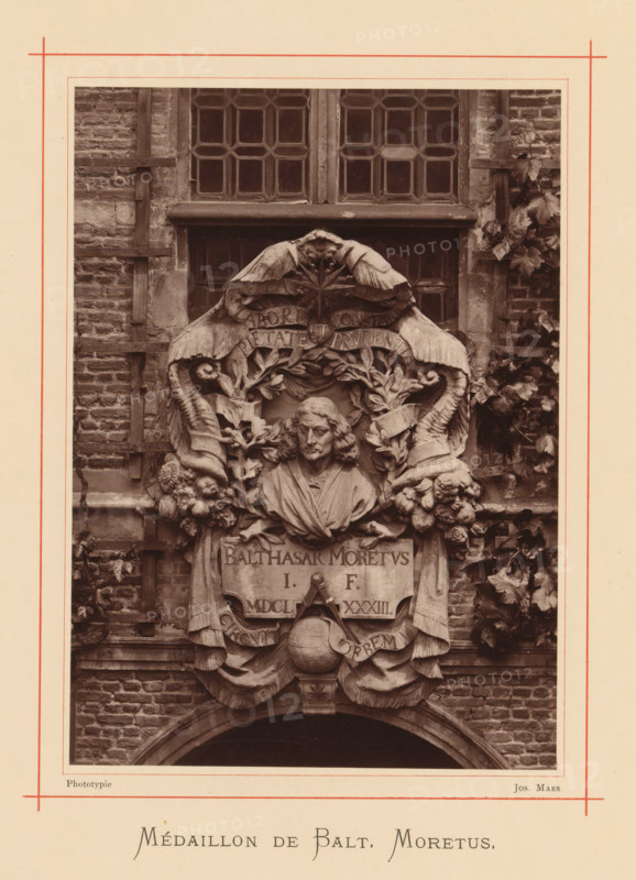 Bust of Balthasar (II) Moretus, Médaillon de Balt. Moretus, page, photomechanical print, maker: Joseph Maes, Antwerp, c. 1873 - in or before 1878, paper, Woodburytype, height 164 mm x width 118 mm, Person, Balthasar Moretus (II), chest, bust, A sepia-toned photograph shows a detailed stone relief mounted on a brick wall beneath a multi-pane window, featuring a carved bust of a man with shoulder-length hair and draped clothing centered within an ornate surround of scrolls, leaves, garlands, floral clusters, and stylized horns; two large wings curve over the top of the relief and a globe with drapery appears below the bust, all framed by climbing foliage and wooden trellis elements against weathered masonry.