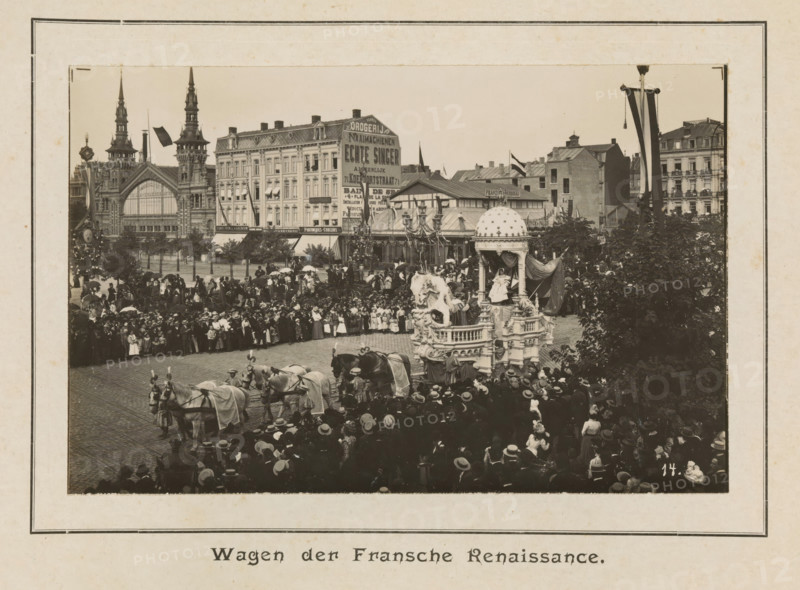 Wagon of the French Renaissance, photograph, page, Antwerp, c. 1899, photographer, paper, printing, height 98 mm x width 152 mm, civic architecture, edifices, dwellings, animal traction, animal-drawn vehicle (carriage etc.), festivities (decorated float, wagon, festive activities), A sepia-toned street scene shows a crowded public square with a large ornate parade float drawn by teams of horses and surrounded by people wearing period clothing and hats. The float features sculptural figures, decorative pillars, and a domed canopy with draped fabric, and a seated figure is visible beneath the canopy. In the foreground a dense crowd lines the cobbled street, with many individuals holding umbrellas and wearing dark coats and wide-brimmed hats. Behind the crowd rows of multistory buildings with varied façades rise along the square, including a building with two tall spires and an arched entrance and other structures with decorative rooflines and awnings. Flags and banners hang from poles an...