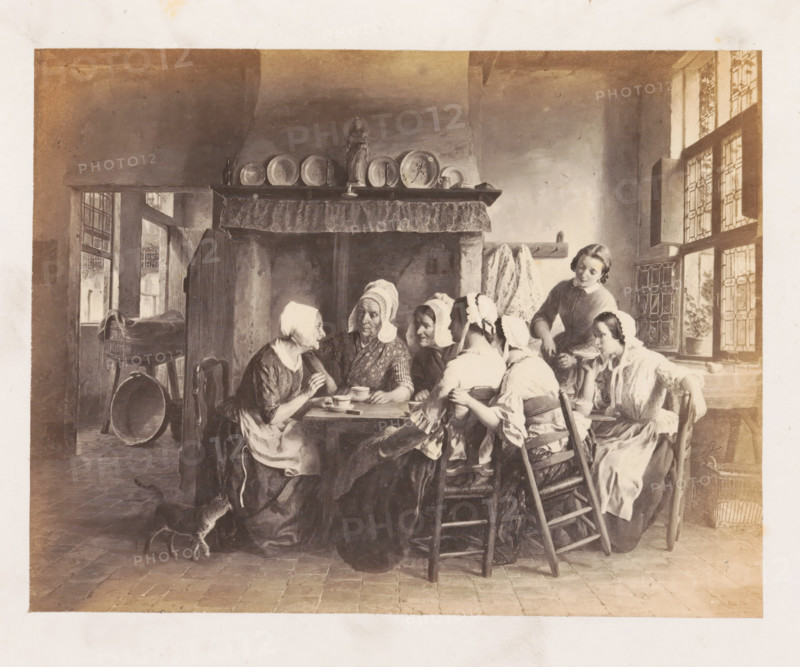 Photo reproduction of Je n'avais que 16 ans by François Antoine De Bruycker, photograph, reproduction, page, after painting by François Antoine De Bruycker, c. 1858 - in or before 1863, François Antoine De Bruycker, photographer, after painting by, paper, albumen print, albumendruk, height 129 mm x width 169 mm, picture, painting, adult woman, kitchen-interior, An interior scene showing a group of people seated around a wooden table in front of a large fireplace with a shelf holding plates and a statue, the figures wearing bonnets and simple clothing, some holding cups and bowls, a young woman standing and serving, a tiled floor, a small dog near the table, a high window with patterned panes and a potted plant on the sill, chairs with woven seats and a cradle or piece of furniture visible in an adjacent room.