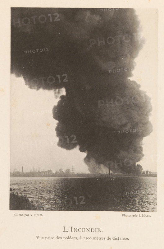 Fire in a hangar with oil after the explosion of a munitions factory in Oosterweel near Antwerp on September 6, 1889, L'Incendie, page, photomechanical print, number: '4', inscription: 'Vue prize des polders, à 1300 mètres de distance.', photographer: Victor Selb, Oosterweel, cliché maker: Joseph Maes, 1885-09-06 - 1889-12-12, Victor Selb, Joseph Maes, photographer, cliché maker, paper, collotype, photoprint, height 165 mm x width 120 mm, smoke, burning, Explosion of a munitions factory in Oosterweel in 1889, A large, dark column of smoke rises from the shoreline and fills most of the upper part of the scene, with billowing, cloudlike edges and varying shades of gray; along the horizon a low strip of land shows silhouettes of masts, smokestacks, and small buildings; the water in the foreground reflects light and has a rippled texture; at the base of the smoke near the shore there are a few small, indistinct boats and shapes.