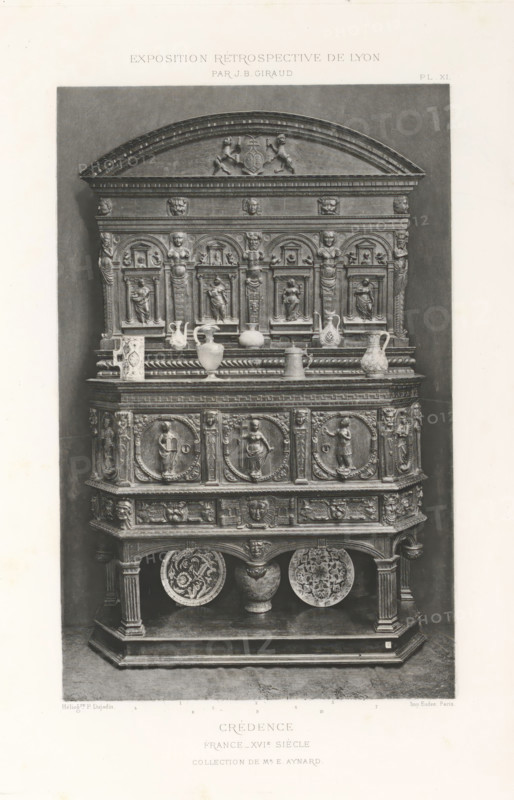16th-century French wooden sideboard, at the Exposition Rétrospective of 1877 in Lyon, France, photomechanical print, This print is part of a cover with 79 prints on 54 sheets and 65 text sheets., inscription: 'EXPOSITION RÉTROSPECTIVE DE LYON, PAR JB GIRAUD.', inscription: 'CRÉDENCE, FRANCE_XVIe SIÈCLE, COLLECTION DE Mr E. AYNARD.', number: 'PL. XI.', photographer: Jacques Garcin, Lyon, clichémaker: Dujardin, printer (person): Imprimerie Eudes, Paris, 1877 - 1878, printer (person), paper, photoaquatint, height 463 mm x width 313 mm, ornamental cupboard (wood and other phytogenic material), A tall ornate wooden cabinet photographed against a plain backdrop, featuring an arched pediment with carved figures and decorative moldings, a middle section with a row of small framed niches each containing carved human figures and fluted pilasters, a ledge displaying various ceramic vessels and jugs, and a lower paneled section decorated with round medallion reliefs of standing figures and intric...