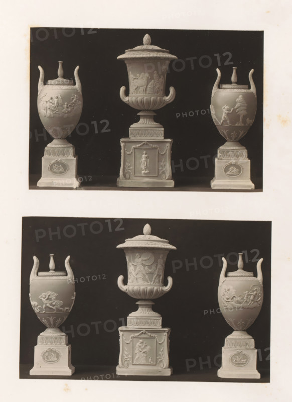 Six decorated vases and bases, photograph, page, photographer: Joseph Cundall, c. 1868 - in or before 1873, paper, carbon print, height 361 mm x width 270 mm, pedestal of a piece of sculpture (perhaps in the form of a herm), container of ceramics: jar, jug, pot, vase, sculpture (relief, sculpture), A monochrome photograph showing two rows of three ornate urns each against a dark rectangular backdrop with a light border, each urn set on a square plinth; the urns feature flared handles, domed lids, and relief decorations depicting human and animal figures and decorative motifs, with central larger urns having more elaborate bases and finials, and side urns presenting rounded bodies with raised scenes and patterned pedestal panels, all arranged symmetrically within the framed dark background.