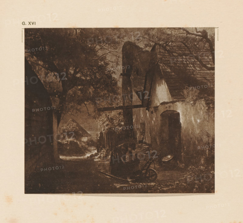Farm, page, photomechanical print, inscription: 'G. XVI.', inscription: 'A quiet retreat by Karl Prokop', photographer: Karl Prokop, cliché maker: anonymous, c. 1900 - in or before 1905, paper, two-color autotype, height 106 mm x width 122 mm, A sepia-toned scene shows a narrow outdoor passage flanked by buildings with sloped roofs and a variety of trees and foliage, a large tree canopy dominates the left side while a smaller tree branch stretches across the upper right; a wooden beam projects from one building toward the center, and a small arched doorway is visible on a building wall; the ground appears uneven with a curved object lying on it and darker shadows in the foreground, while lighter tones suggest a distant opening or clearing beyond the passage.