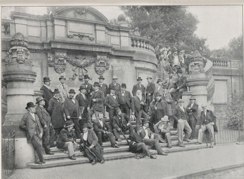 Die Teilnehmer der Vertrauensmänner-Versammlung des Rechtsschutzverbandes Deutscher Photographen zu Dresden, Group portrait of the participants in a meeting for confidential counselors of the Rechtsschutzverbandes Deutscher Photographen in Dresden, page, photomechanical print, monogram: 'LEIPZIG, S G', name: 'Loevinson, Nürnberg, Glock, Würzburg, Brand, Mittweida i. S., Ostermayer, Munich', photographer: Heinrich Ranft, Dresden, cliché maker: unknown, Leipzig, c. 1895 - in or before 1900, Saxony, paper, autotypie, height 144 mm x width 200 mm, anonymous historical persons depicted in a group, in a group-portrait, A large group of men in formal suits and hats are gathered on wide stone steps in front of an ornate stone building with carved decorative elements and balustrades, some men standing, some sitting or reclining on the steps, many holding walking sticks or canes, with a few women and children visible on the upper curved staircase and balcony area, large sculpted pillars flanking...