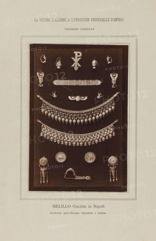 Melillo Giacinto in Napoli, Earrings and necklaces, La Section Italienne a l'Exposition Universelle d'Anvers - Troisième Fascicule, photograph, page, inscription: 'Oreficeria greco-Etrusca riprodotta e imitata.', c. 1880 - in or before 1885, photographer, paper, albumen print, height 162 mm x width 108 mm, Photo on loose plate opposite page 56., ear-rings, necklace, A photographic plate centered on a dark rectangular panel displays an arrangement of various metallic jewelry pieces and ornamental elements mounted against the dark background, including paired decorative heads and small relief figures near the top, a central emblem with a vertically oriented symbol flanked by two human-profile earrings, a horizontal engraved bar with geometric panels, a winged scarab-like ornament, two large semicircular fringe necklaces composed of repeated teardrop and floral-shaped pendants, a series of round medallions and shield-like discs, paired long pendant earrings with tapered drops and bead cha...