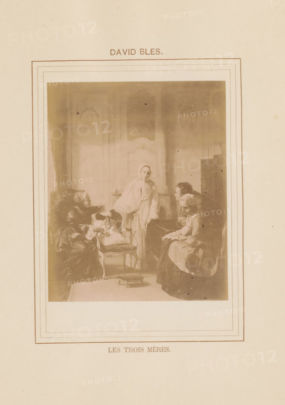 Les trois mères, Photo reproduction of Les trois mères by David Bles, photograph, reproduction, page, inscription: 'David Bles', after painting by David Bles, c. 1878 - in or before 1883, photographer, paper, albumen print, height 134 mm x width 98 mm, adult man, painting, drawing and the graphic arts, A sepia-toned rectangular image centered on a cream background shows an indoor scene with four women in period clothing gathered in a furnished room; one woman stands near the center wearing a light shawl, another sits on a cushioned chair to the left with a wrapped bundle on her lap, a third woman sits on the right holding an object in her arms while a fourth leans forward from a chair near the right edge; visible furniture includes upholstered chairs and a small footstool on the floor, paneled walls with decorative molding form the backdrop, and a double-lined rectangular border frames the scene on the page.