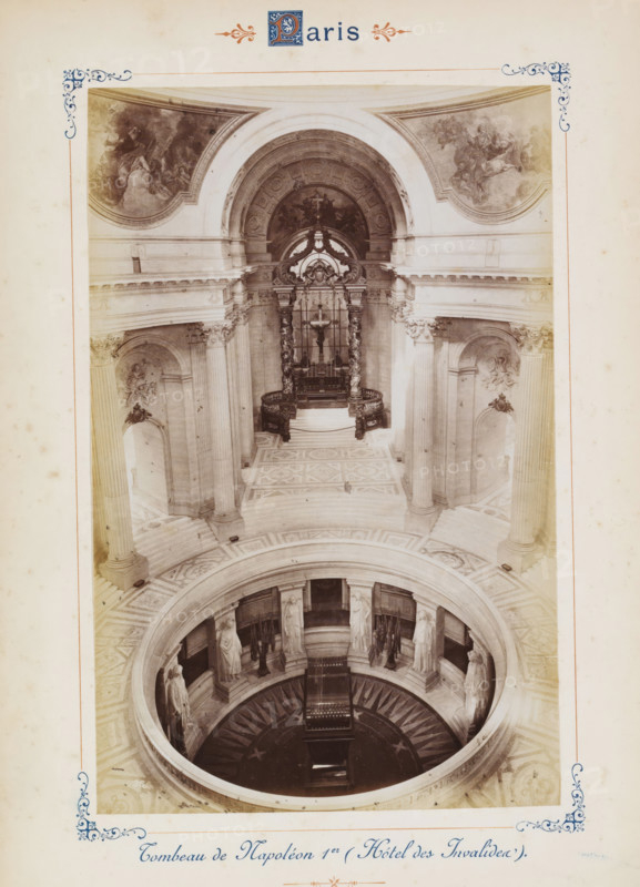 Eglise de la Madeleine, View of La Madeleine in Paris, photograph, page, number: '3', Paris, c. 1879 - c. 1889, photographer, paper, albumen print, albumendruk, height 120 mm x width 188 mm, church (exterior), façade (of house or building), La Madeleine (place), A sepia-toned photograph of an ornate interior showing a circular rotunda with a patterned floor and a central round opening that reveals a lower level; the upper area features tall fluted columns with decorative capitals, arched niches containing sculpted reliefs, and a raised altar area framed by twisted columns and an ornate canopy; frescoed lunettes adorn the curved sections above the arches; marble stairs and an intricately tiled floor radiate around the central opening, and sculpted standing figures are positioned in recesses facing the aperture.