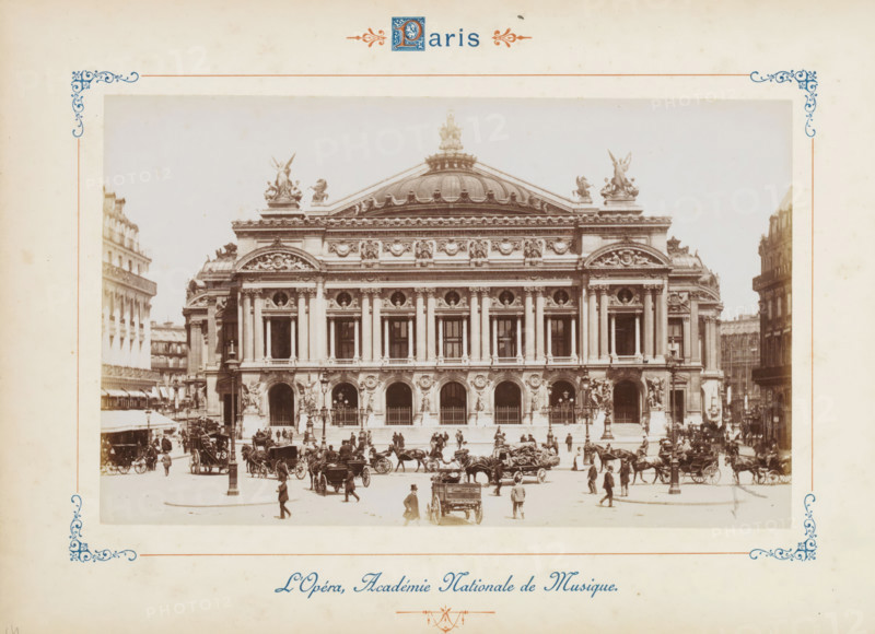 L'Opéra, Académie Nationale de Musique, Facade of the Opéra Garnier in Paris, photograph, page, number: '73', Paris, c. 1879 - c. 1889, photographer, paper, albumen print, albumendruk, height 120 mm x width 188 mm, four-wheeled, animal-drawn vehicle, eg: cab, carriage, coach, façade (of house or building), opera house, Opéra de Paris, A wide sepia photograph of a grand neoclassical building with a domed roof and ornate sculptures along the cornice, framed by decorative corner motifs on a cream page; the building facade features tall columns, arched openings at ground level, and sculptural reliefs above the windows, while a busy street scene in front shows many horse-drawn carriages, horses, and people walking or standing, some in hats and coats, with lampposts and steps leading up to the building.