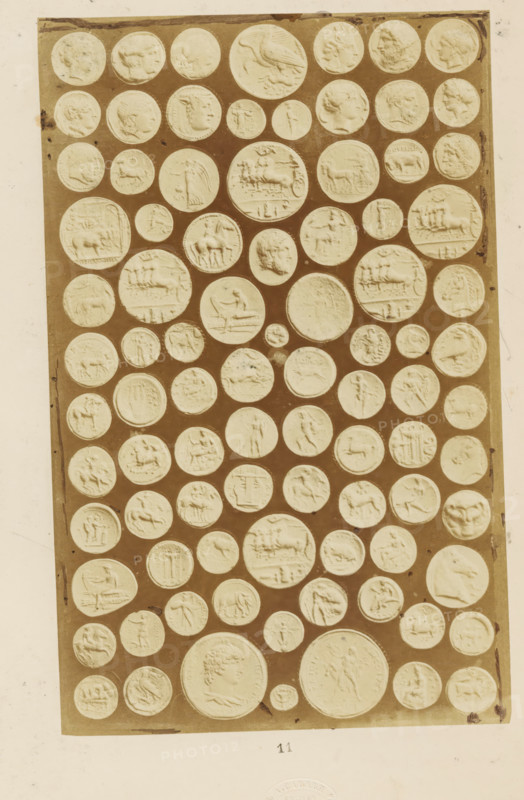 Antique medals, photograph, page, name: 'A. Cadart 3. Rue St. Fiacre Paris Editeur', number: '11', Rome, c. 1849 - in or before 1859, photographer, paper, albumen print, height 200 mm x width 126 mm, medal (considered as a piece of sculpture, regardless of its specific function), A rectangular panel filled with many round, raised medallions arranged in rows against a darker background, each medallion showing low-relief profiles, animals, chariots, and various figurative scenes; the medallions vary in size and display carved faces in profile, horses, riders, standing figures, and animals, with some circular impressions showing wreaths or decorative borders, all set within a light tiled area bordered by a lighter margin.
