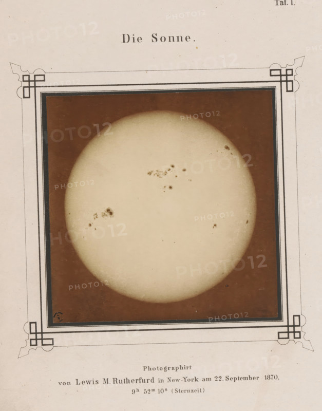 View of the sun, Die Sonne, photograph, page, number: 'Taf. I.', inscription: 'Photographirt von Lewis M. Rutherfurd in New York- am 22. September 1870, 9h 52m 10s (Sternzeit)', photographer: Lewis Morris Rutherfurd, New York (city), printer (person): Friedrich Hundt, Münster (North Rhine-Westphalia), publisher: Georg Westermann, London, 1870-09-22 - 1872, printer (person), North Rhine-Westphalia, North America, paper, albumen print, height 92 mm x width 92 mm, Photo opposite title page., sun as celestial body, A faded rectangular image framed by a decorative border shows a large pale circular disk against a darker background, with several irregular darker spots and clusters on the disk surface and subtle shading toward its edge; the surrounding paper has an off-white tone with small speckles and ornamental corner designs.