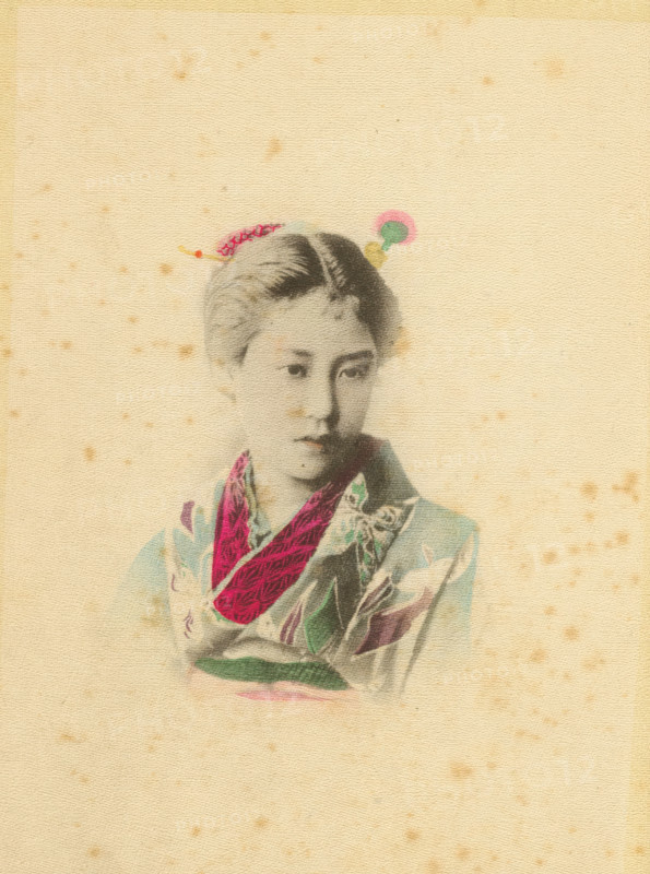 A damsel, page, photomechanical print, Japan, cliché maker: Kazumasa Ogawa, c. 1886 - in or before 1896, photographer, paper, crepe paper, collotype, hand coloring, height 176 mm x width 124 mm, adult woman, A faded portrait of a young person wearing a patterned garment with a bright scarf draped around the neck, the face rendered in soft grayscale with a neutral expression and short hair, small decorative hair ornaments visible atop the head, all set against a textured, aged beige background with scattered small brown speckles.