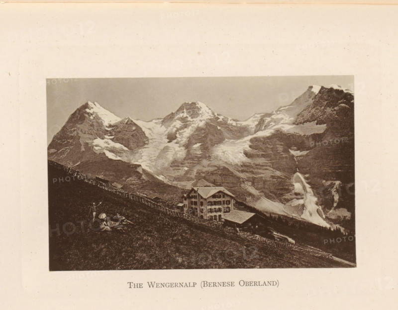 View of the Wengernalp in the Bernese Oberland, The Wengernalp (Bernese Oberland), page, photomechanical print, Bern (canton), c. 1874 - in or before 1884, paper, collotype, photoprint, height 86 mm x width 136 mm, mountains, mountain-range, snow peaks, A sepia-toned photograph shows a steep grassy hillside with a wooden fence running diagonally across it, a multi-story chalet-style building with a pitched roof and multiple windows situated partway down the slope, and a rugged mountain landscape behind with jagged peaks capped in snow and glaciers flowing down rocky faces, while a steep waterfall or icefall descends on one side of the mountains.