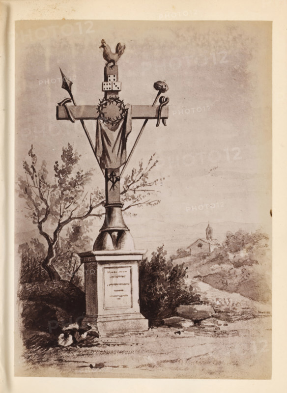 Photo reproduction of a drawing of a cross with references to the Passion of Christ outdoors, presumably in Italy, photograph, reproduction, page, after drawing by anonymous, c. 1850 - in or before 1860, photographer, paper, albumen print, height 134 mm x width 97 mm, the cross, symbols of Christ, A tall stone monument topped by a cross stands in the foreground, with a rooster figure perched on a small block at the top and a crown of thorns hanging from the horizontal beam; a cloth drapes down from the cross and two diagonal supports meet at the central shaft above an ornate pedestal. Trees and bushes surround the base of the monument on one side, and a winding path or road leads into the middle distance where a small building with a steeple is visible amid low hills and scattered vegetation. The scene is rendered in a monochrome, sketch-like style with visible shading and texture across the sky and landscape.