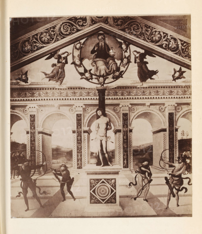 Photo reproduction of probably a fresco of Saint Sebastian, photograph, reproduction, page, Italy, after painting by anonymous, c. 1850 - in or before 1860, photographer, paper, albumen print, height 105 mm x width 94 mm, the martyr Sebastian, possible attributes: arrow(s), bow, tree-trunk, A vertical photograph of a decorative wall featuring an upper triangular pediment with ornate scrolling foliage and a round medallion at its center containing a seated bearded figure surrounded by small winged heads, flanked by angels in flowing robes; below the pediment a frieze with floral motifs tops a row of arched niches supported by decorated columns, the central niche containing a standing male statue with a draped cloth; in the foreground four figures with bows and arrows stand in dynamic poses at the corners, two on each side, against a tiled floor and a pedestal with a square decorative panel at its front.