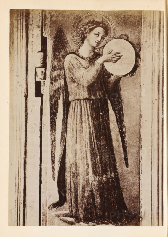 Photo reproduction of a detail of the Tabernacolo dei Linaioli by Fra Angelico, depicting an angel with a tambourine, photograph, reproduction, page, Italy, after painting by Fra Angelico, c. 1850 - in or before 1860, photographer, paper, albumen print, height 134 mm x width 97 mm, angels, tambourine, A sepia-toned image of a standing angel with a halo, long curly hair, and feathered wings, wearing a long flowing robe with pleats and holding a round, flat object with both hands near chest level; the angel's head is slightly tilted and the facial expression is calm, the wings extend down past the waist, and the figure is framed by vertical architectural elements on either side with visible worn textures and shadows.