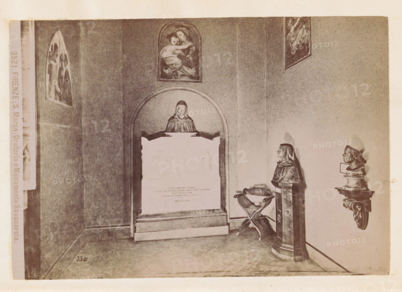 Oratory in the San Marco Monastery in Florence with a monument to Girolamo Savonarola, Firenze (S. Marco) Oratorio e Monumento Savonarola, photograph, page, number: '3521.', photographer: Fratelli Alinari (possibly), San Marco, c. 1878 - in or before 1888, Florence, Tuscany, paper, albumen print, height 100 mm x width 144 mm, monument, statue, abbey, monastery, convent, Roman Catholic church, interior, representation of a building, A sepia-toned interior scene showing a wall with framed religious paintings and sculpted busts mounted on pedestals, a recessed arched niche containing a plaque topped by a carved figure, an ornate basin with crossed supports standing beside a tall pedestal, and a tiled floor leading to the corner of the room.
