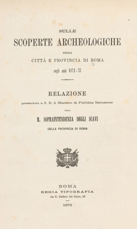 Sulle scoperte archeologiche della città e provincia di Roma negli anni 1871-72, book, inscription: 'British School of Rome duplicate', 1873, pasteboard, paper, printing, albumen print, height 272 mm x width 185 mm x thickness 15 mm, A cream-colored aged paper page with darker age spots and small stains scattered across the surface, featuring a centered ornamental emblem with a crowned shield and decorative flourishes, and multiple lines of printed serif text arranged above and below the emblem, all aligned down the vertical center of the page.