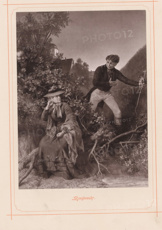 Rangdewuh, Photographic reproduction of a painting of a woman sitting by a brook with a young man behind her, reproduction, page, photomechanical print, maker: Friedrich Bruckmann, after painting by Konrad Beckmann, c. 1874 - in or before 1884, paper, collotype, photogravure, height 175 mm x width 128 mm, picture, painting, adult woman, river, A monochrome illustration framed by a decorative border shows a seated woman in layered clothing and a wide-brimmed hat with a scarf tied around her neck, her hand raised near her face and the other resting on her lap, sitting on a root-strewn bank amid foliage; nearby a young man in a dark jacket and light trousers stands on the bank holding a long staff, one hand pressed to his chest and his body angled toward the woman; behind them dense bushes and tree branches fill the left side, with a concealed face peering from the foliage, and in the background rooflines and a distant tower silhouette rise against a softly shaded sky, while the foregroun...
