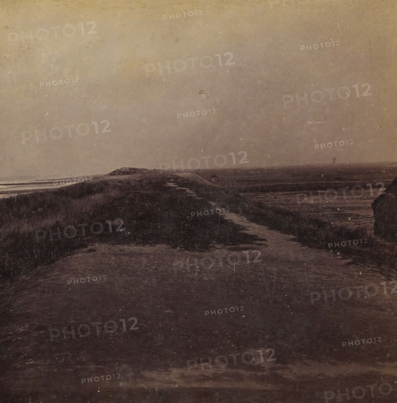Just wide enough, View of the dune strip near Ter Heijde, Views and landscapes in Europe, Africa and Asia, Geographical Sculpture Gallery, collected by MJ Broekhuijsen, Headmaster of a school in Amsterdam, stereograph, Numbered A.4. at the bottom left of the photo, annotation: 'is near Ter Heijde the dune strip, continually excavated further by humans, to enlarge the area of the geestgronden on the right. Compare the height of the sea level and of the geestgrond., Rectangular on the dune strip in the sea are the piers.', Ter Heijde, publisher: Merkelbach & Co., Amsterdam, compiler (person in literature): Martien Johan Broekhuijsen, c. 1905, photographer, compiler (person in literature), pasteboard, paper, albumen print, height 87 mm x width 177 mm, Part of a group of 52 stereophotos used in primary education as a supplement to school charts. The entire series consisted of 274 items in 10 categories (A to K)., Dune Coast, A muted landscape with a wide expanse of sky above a low, rolling...